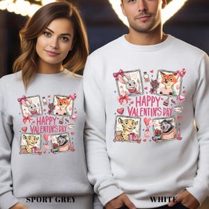 A woman and a man are standing next to each other, both wearing white sweaters with a graphic design featuring cartoon animals and the text "Happy Valentine's Day".