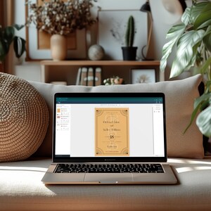 May include: A laptop displaying a wedding invitation design. The invitation features a tan background with decorative black borders and the names "Helena Laine" and "Kelle William." The number "18" is prominently displayed. The laptop is open on a beige couch.