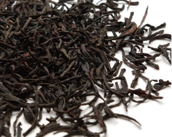May include: Loose black tea leaves, dried and ready for brewing. The tea leaves are long and thin, with a dark brown color.