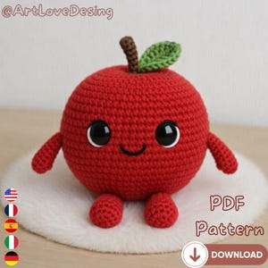 Könnte beinhalten: Ein gehäkelter roter Apfel mit schwarzen Augen, einem lächelnden Mund und kleinen Armen und Füßen. Der Apfel hat einen braunen Stiel und ein grünes Blatt. Das Bild enthält den Text "PDF Pattern" und "Download".