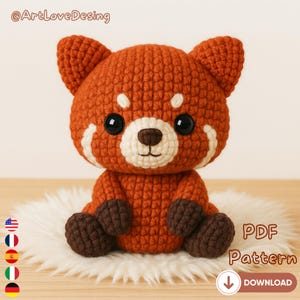 May include: A crocheted red panda toy in shades of orange and brown, with white markings and dark brown paws. The plushie sits on a white, fluffy surface. The image includes the text "PDF Pattern" and a download arrow.