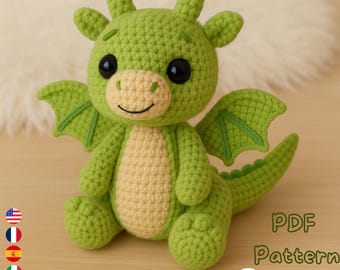 May include: A crocheted green dragon with a light tan belly and face, black eyes, and small wings. The dragon is sitting with its legs forward. The image includes the text "PDF Pattern Download".