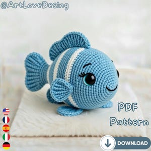 May include: A crocheted blue fish with white stripes, large black eyes, and a smiling mouth. The fish has fins and a tail. The image includes the text "PDF Pattern" and a download icon.