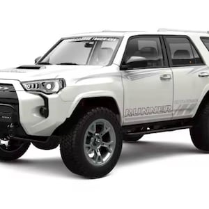 May include: White Toyota 4Runner SUV with black detailing, a black front bumper, and large off-road tyres. The word "RUNNER" is visible on the side. The vehicle has a roof rack and the text "ROCKY MOUNTAIN TRUCK AXE" on the windscreen.