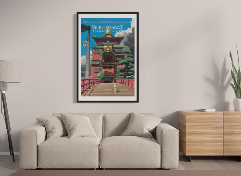 May include: A black framed poster with a colorful illustration of a building with a red bridge leading to it. The poster has the text "Spirited Away" in white letters on a black background.