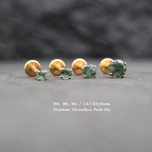 May include: Four gold-tone titanium threadless push pin earrings with round moss agate stones in varying sizes. The text 20G, 18G, 16G / 5, 6, 7, 8, 9, 10mm Titanium Threadless Push Pin is visible. Each earring features a flat back and a prong setting.