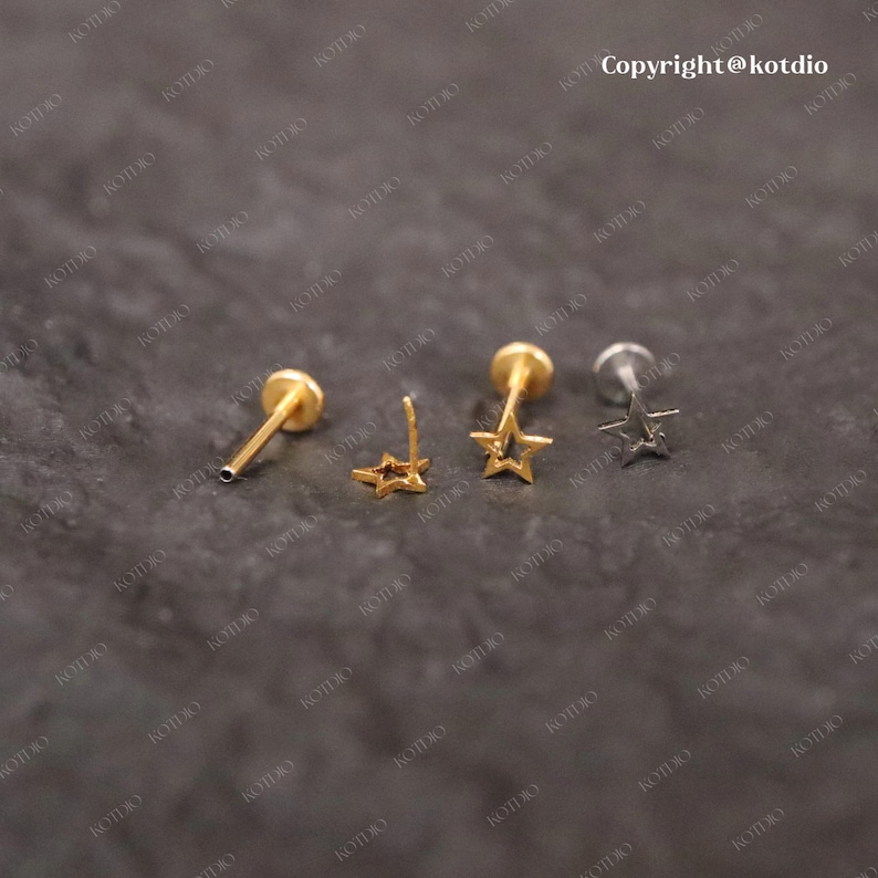 Op de afbeelding: Drie neusringen met stervormige bedels. De ringen zijn gemaakt van goud en zilver metaal. De sterbedels zijn goud.