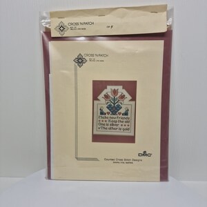 May include: A cross stitch pattern with a red, white, and blue color scheme. The pattern features a bouquet of flowers and the text "Make new friends, keep the old. One is silver, the other is gold." The pattern is from Cross 'N Patch, a counted cross stitch design company.