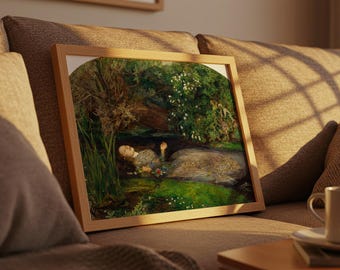 May include: A framed print of a painting depicting a woman floating in a stream, surrounded by lush greenery and flowers. The artwork is in a light wooden frame, resting on a brown sofa with a coffee cup.