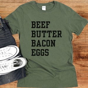 May include: A green t-shirt with the text "BEEF BUTTER BACON EGGS" printed in black.