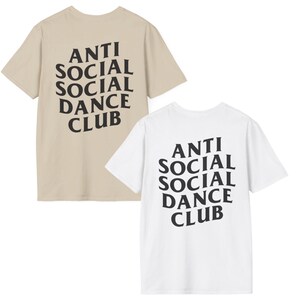 May include: Two t-shirts, one beige and one white, each with the text "ANTI SOCIAL SOCIAL DANCE CLUB" printed in black. The text is in a bold, stylized font.