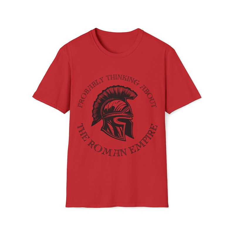 May include: Red t-shirt with a black graphic of a Roman helmet inside a circle with the text "Probably thinking about the Roman Empire".