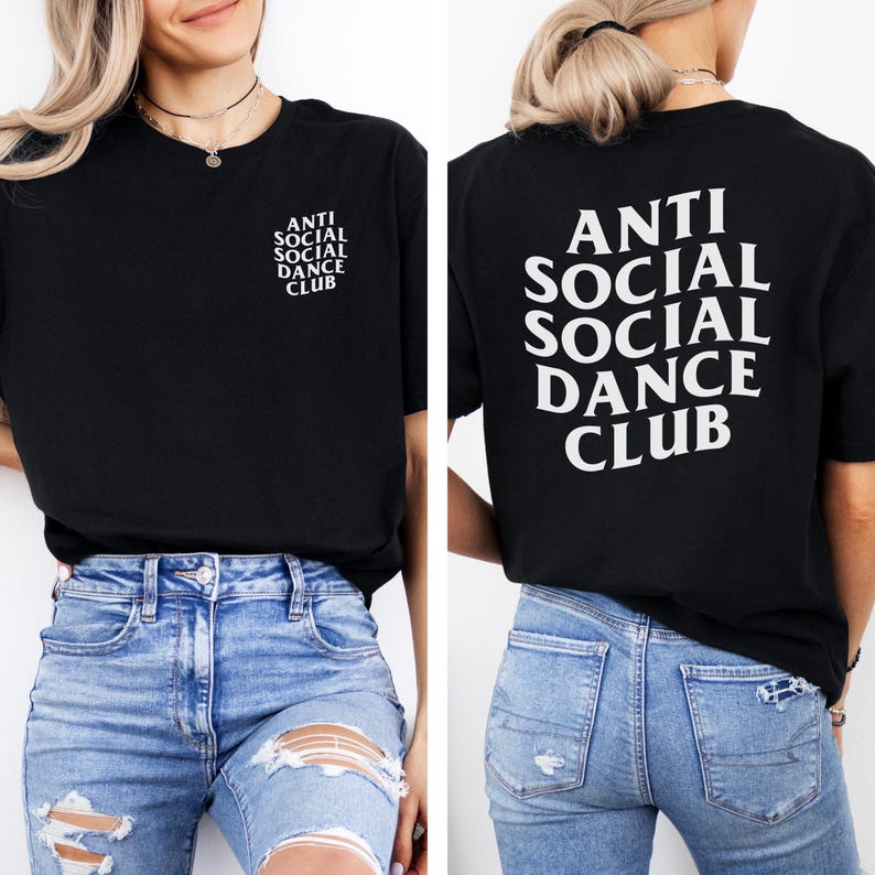 May include: Black t-shirt with the text "ANTI SOCIAL SOCIAL DANCE CLUB" printed in white on the front and back. The shirt is a crew neck and has short sleeves. The model is wearing blue jeans.
