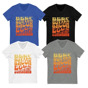 May include: Four V-neck t-shirts in different colors with the text "BEEF BUTTER BACON EGGS SUNSHINE" in a retro font. The text is in a gradient of orange and yellow.