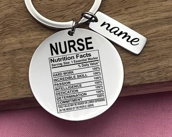 May include: Silver keychain with a round tag that says "NURSE" and lists "Nutrition Facts" with a variety of skills and qualities, all listed as 100% daily value.  The tag also has a smaller tag that says "name".