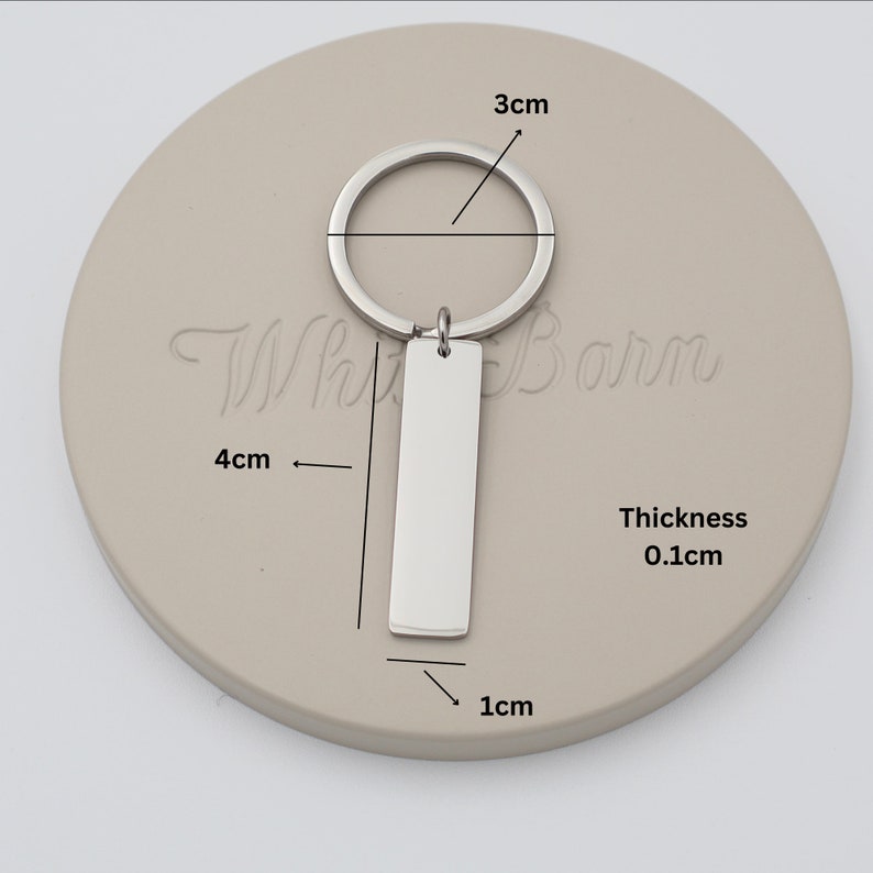 a white clock with a metal key on it