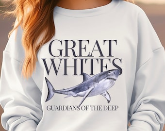 Pode incluir: Camisola branca com um gráfico de um grande tubarão branco e o texto "GREAT WHITES GUARDIANS OF THE DEEP".