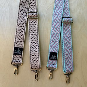 May include: Two adjustable bag straps with a chevron pattern. The left strap features brown and beige zigzags, while the right strap displays teal, pink, and white zigzags. Both include bronze-toned metal hardware and a black label reading LO HAZEL.