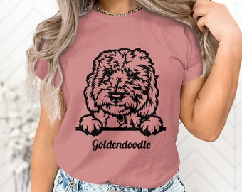Puede incluir: Camiseta rosa polvoriento con un dibujo lineal negro de un perro Goldendoodle. Se ven la cabeza y las patas del perro, con la palabra "Goldendoodle" impresa en una fuente cursiva debajo.