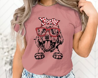 Puede incluir: Camiseta rosa polvoriento con un gráfico en blanco y negro de un perro con gafas rojas y un pañuelo de lunares rojos. La lengua del perro está fuera. La camiseta tiene mangas cortas y cuello redondo.