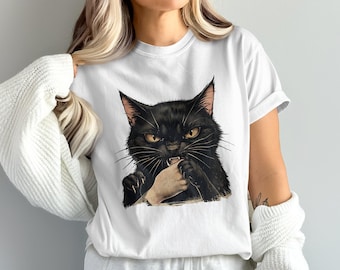 May include: A white short-sleeved t-shirt featuring a graphic illustration of a black cat with yellow eyes biting a human hand. The cat has sharp claws and whiskers, and the design is centered on the chest of the garment.