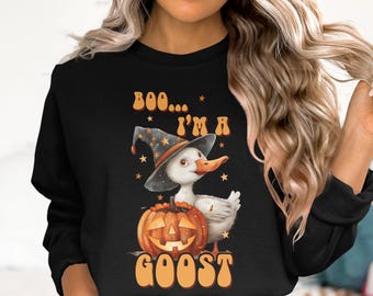 May include: Black sweatshirt with a Halloween graphic. The design shows a white duck in a witch's hat, beside a carved pumpkin. The text reads "Boo... I'm a GOOST" in orange.