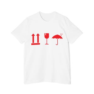 May include: White t-shirt with red shipping symbols: two upward arrows, a broken glass, and an umbrella with raindrops. The shirt is a classic crew neck style.