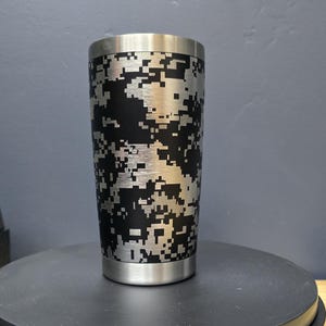 May include: A stainless steel tumbler with a black and white digital camouflage pattern.