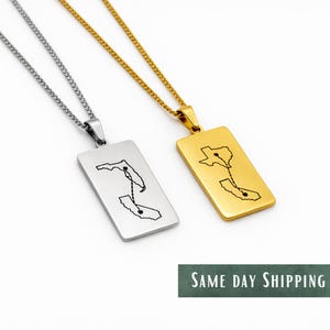 May include: Two rectangular pendant necklaces, one silver and one gold, each with a chain. The silver pendant features a map outline of Florida and California. The gold pendant shows Texas and California. Both have black line details.