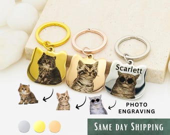 Op de afbeelding: Drie kattenvormige sleutelhangers met fotogravure. De sleutelhangers zijn goud, rosé goud en zilver. De sleutelhangers tonen verschillende kattenfoto's en de naam "Scarlett" is op een sleutelhanger gegraveerd.