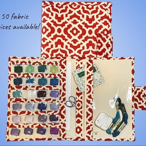May include: A red and white patterned fabric organizer, open to display embroidery floss, scissors, and other craft supplies. The text "50 fabric choices available!" is visible. The organizer is designed to hold various craft items.