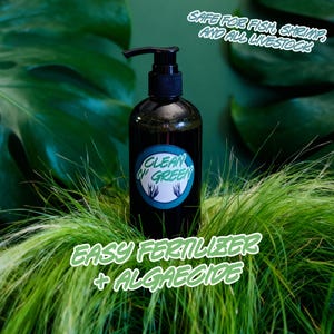 May include: A dark green bottle with a black pump dispenser, labeled "Clean 'N Green." The bottle sits in green grass, with text reading "Easy Fertilizer + Algaecide" and "Safe for Fish, Shrimp, and All Livestock."