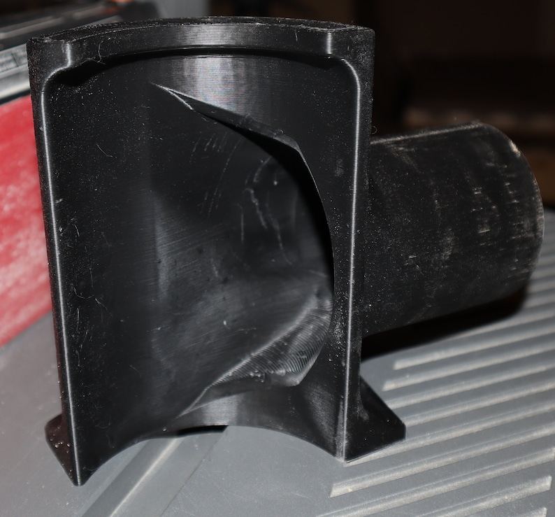 Pu&ograve; includere: Un adattatore per la raccolta della polvere in plastica nera con un'apertura curva e un tubo dritto.