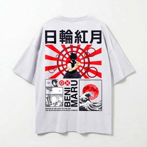 May include: White t-shirt with a Japanese-inspired graphic. The design includes Japanese text, a red sun, a figure, and a wave with a red moon. The text "BENI MARU" is also visible.