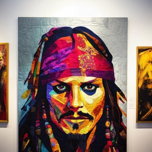 Peut inclure: Un portrait de quilt coloré d'un homme avec une barbe et un bandana. L'œuvre présente une palette vibrante de rouges, de bleus, de jaunes et de verts, créant un effet de mosaïque. Le portrait est exposé sur un mur dans un cadre de galerie.
