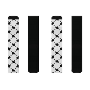 Könnte beinhalten: Vier Paar Socken, zwei schwarze und zwei mit einem weißen und schwarzen geometrischen Muster.
