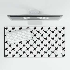 May include: A computer setup featuring a white keyboard, mouse, and a black and white patterned mousepad. The mousepad has a geometric design of black ovals on a white background. A computer monitor is positioned above the mousepad.