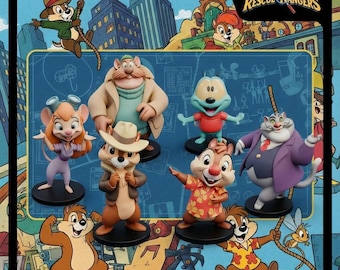 Może przedstawiać: Kolekcja figurek Chip i Dale: Brygada RR. Figurki przedstawiają Chipa, Dale'a, Gadget, Monterey Jacka, Zipper i Grubego Kota. Tło przedstawia krajobraz miejski i logo serialu.