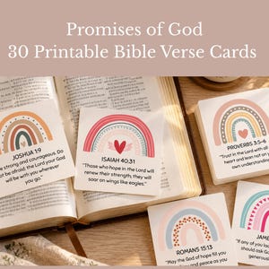 May include: A set of 30 printable Bible verse cards featuring rainbow illustrations and text including Joshua 1:9, Isaiah 40:31, Proverbs 3:5-6, Romans 15:13, and James 1:5. The cards are displayed alongside an open Bible and a wooden cross.