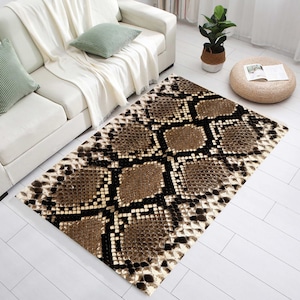 May include: A rectangular rug with a snakeskin design. The rug has a repeating pattern of brown, tan, and black diamond shapes, giving a textured look. The rug is placed on a white floor.