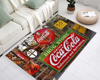 Könnte beinhalten: Ein Coca-Cola-Teppich im Vintage-Stil mit einem roten Coca-Cola-Schild mit dem Text "Drink Coca-Cola Delicious and Refreshing", einem roten Coca-Cola-Flaschenverschluss, einem grünen "Drug Store"-Schild, einem gelben "50 MPH"-Schild und einem roten "Phillip 66"-Schild.
