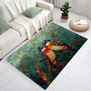 Puede incluir: Alfombra rectangular con un diseño de mosaico que representa dos pájaros en una rama. Los pájaros tienen la cabeza azul, el pecho naranja y las alas marrones. El fondo de la alfombra es una mezcla de tonos turquesa, verde y naranja.