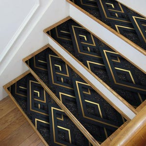 May include: Black and gold geometric patterned stair treads. The pattern features a repeating diamond shape with gold lines.