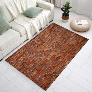 May include: A red brick patterned area rug with a distressed look. The rug is laid out on a white wood floor in a living room setting.