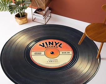 Könnte beinhalten: Ein runder schwarzer und goldener Vinyl-Platten-Teppich mit dem Text "Vinyl Record" in Orange und Schwarz. Die Platte hat ein Etikett mit dem Text "100C. 80" und "AB1101" in Orange und Schwarz.