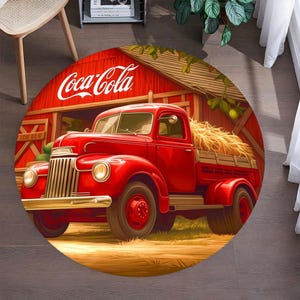 Könnte beinhalten: Ein roter Oldtimer-LKW mit einer Holzpritsche steht vor einem roten Schuppen mit dem Schriftzug "Coca-Cola" an der Seite. Der LKW ist von Heuballen und grünen Pflanzen umgeben.