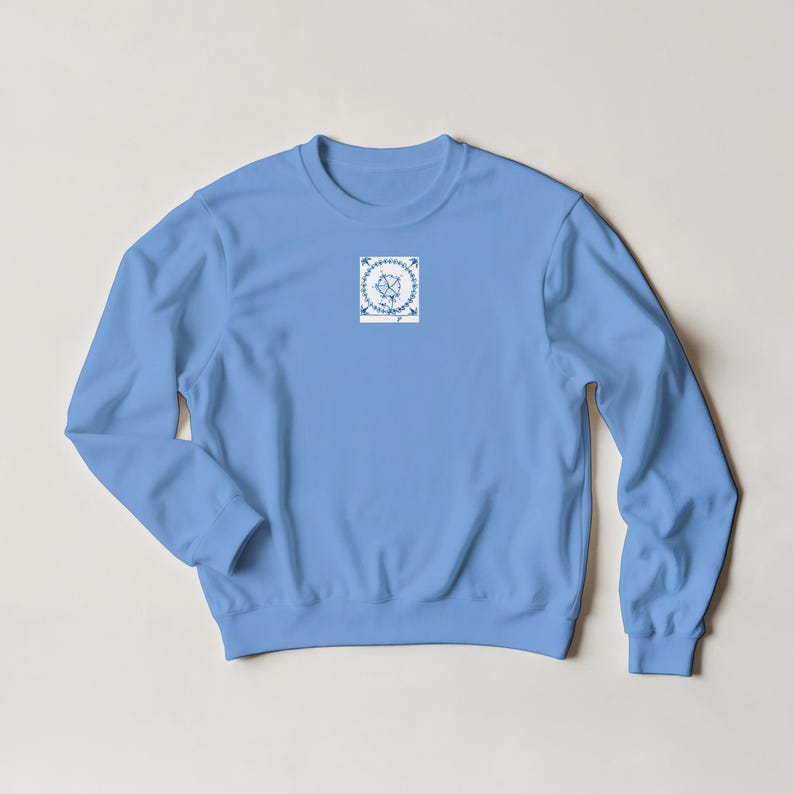 K&ouml;nnte beinhalten: Hellblaues Sweatshirt mit Rundhalsausschnitt und langen &Auml;rmeln. Das Sweatshirt hat eine kleine, quadratische Grafik auf der Brust mit einem blau-wei&szlig;en Blumendesign. Die Grafik enth&auml;lt den Schriftzug "love" in Schreibschrift.