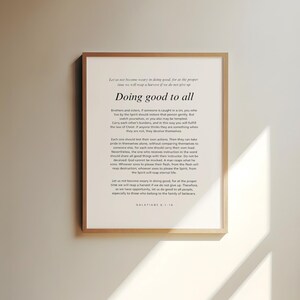 May include: A framed print with the text "Doing good to all" in a serif font. The print has a light-colored background with a wooden frame. The text is a quote from Galatians 6:9-10.