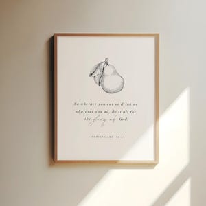 Peut inclure: Impression encadrée avec une illustration de poire et du texte. L'impression indique : « So whether you eat or drink or whatever you do, do it all for the glory of God. 1 CORINTHIANS 10:31 ». Le cadre est de couleur marron clair, l'œuvre est en noir et blanc.
