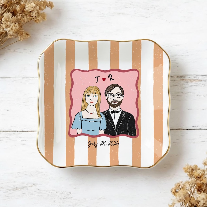 Pu&ograve; includere: Un piattino quadrato in ceramica con bordi ondulati e un bordo dorato. La superficie presenta strisce verticali color pesca e bianche. Un'illustrazione centrale raffigura una coppia con il testo T R, un cuore rosso e la data July 24, 2026.